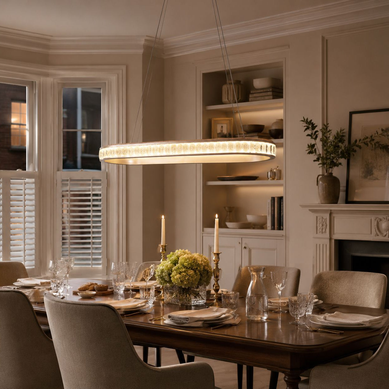 champagne gold oval crystal pendant light over a classic dining room table