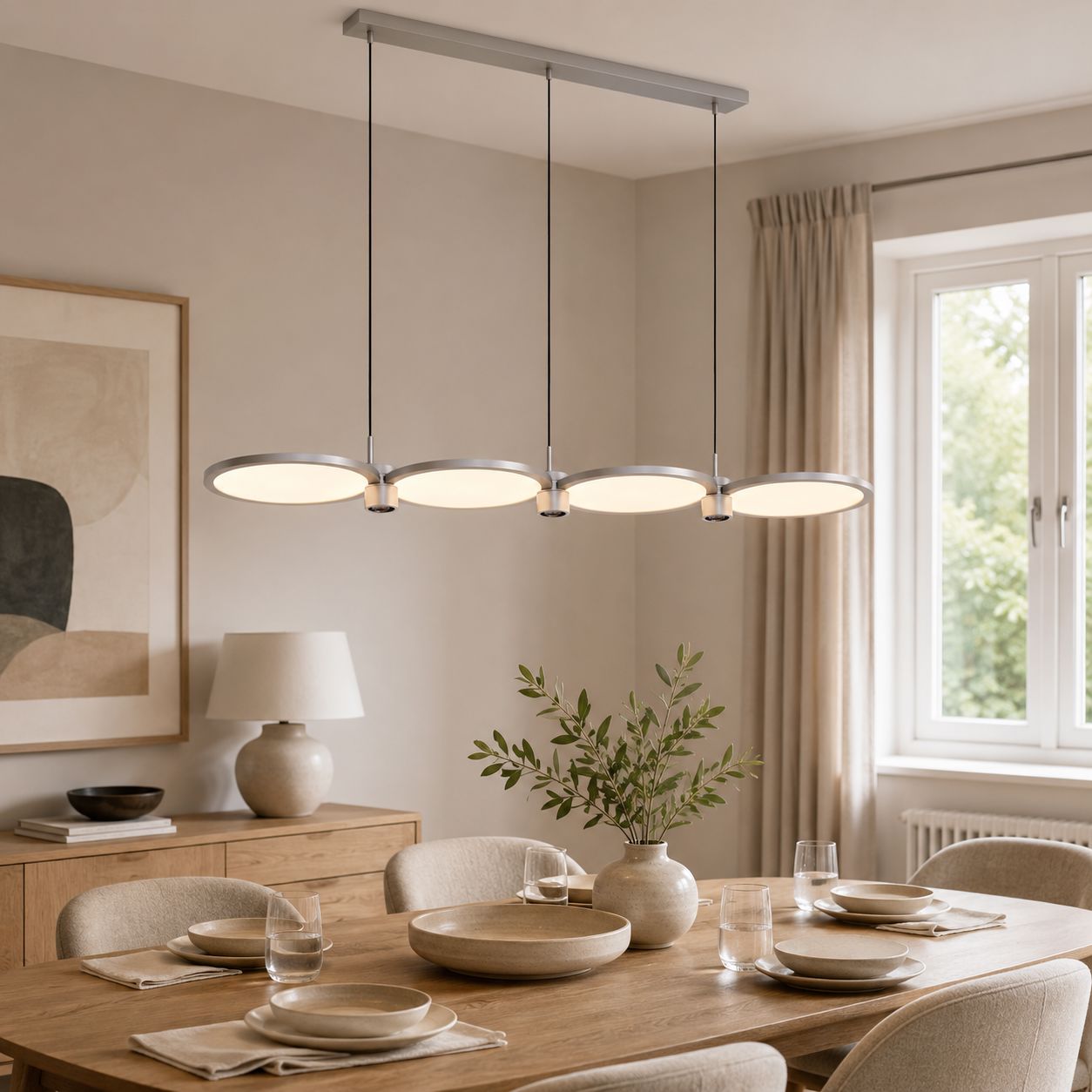 silver linear pendant over a round dining table by a window