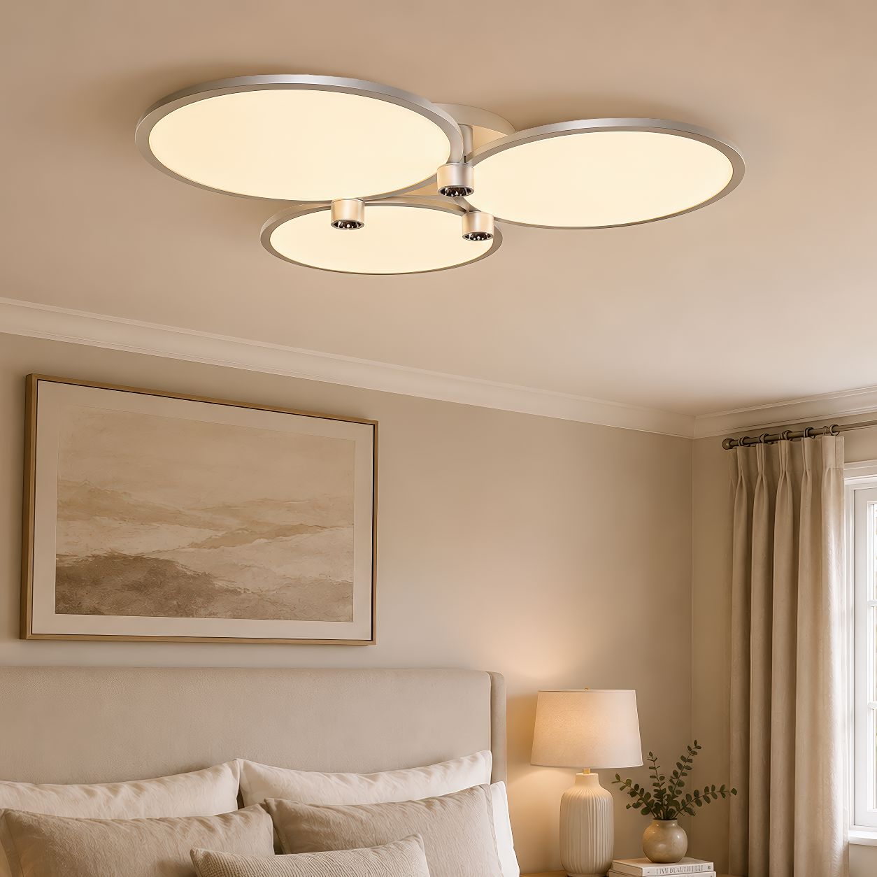 silver three-disk ceiling light above a bedroom